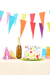Obraz premium Bottle of sparkling wine, plastic glasses, party hats and birthd