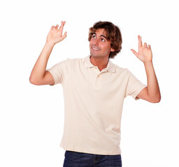 Fototapeta premium Attractive man crossing fingers while looking up