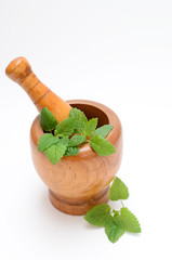 wooden mortar with melissa leaves