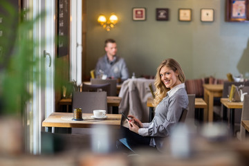 Pregnant Woman Using Digital Tablet At Coffeeshop