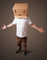 Young man gesturing with a cardboard box on his head with smiley