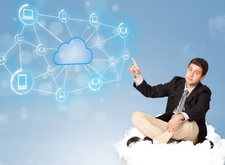 Happy businessman sitting on cloud with cloud computing