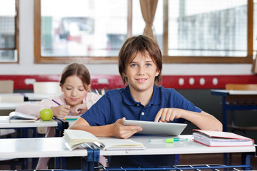 Schoolboy Using Digital Tablet In Classroom