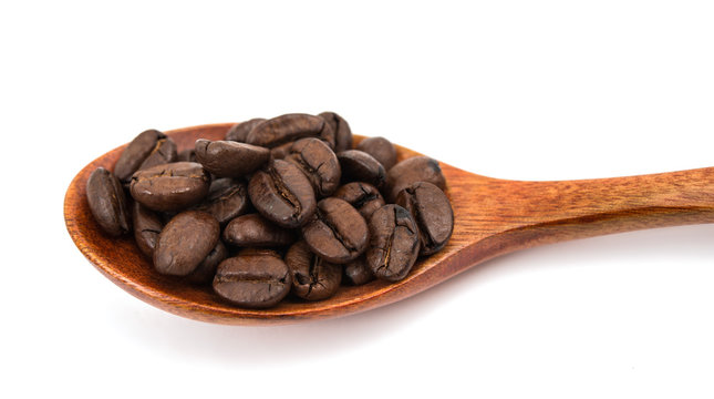 Coffee beans in a wooden spoon isolated
