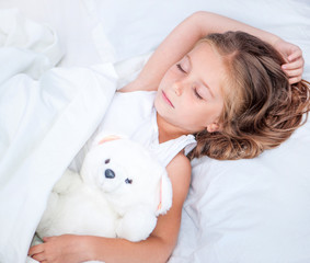 little girl  in the  bed with teddy bear