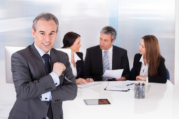 Businessman Standing In Front Of His Colleagues