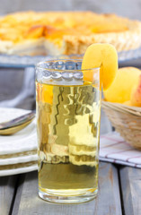 Peach drink. Apricot pie on cake stand in the background