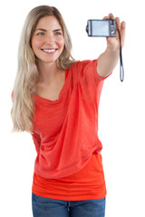 Smiling blonde woman taking picture of herself