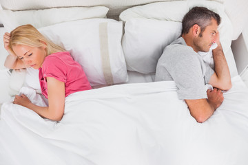 Upset couple lying back to back