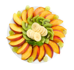 Assortment of sliced fruits on plate, isolated on white