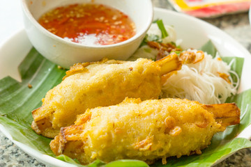 Fried shrimp on sugar cane and sauce.
