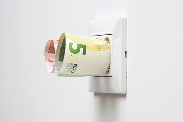 energy savings concept with power socket and money