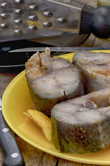 Pickled pieces of fish on a yellow dish