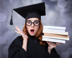 graduating student girl in an academic gown with books