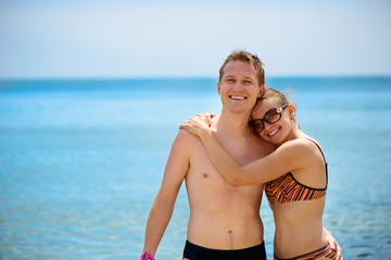 Fototapeta premium Young man and beautiful girl smiling at ocean beach