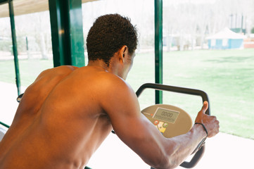 Black man during a stationary bike session at gym