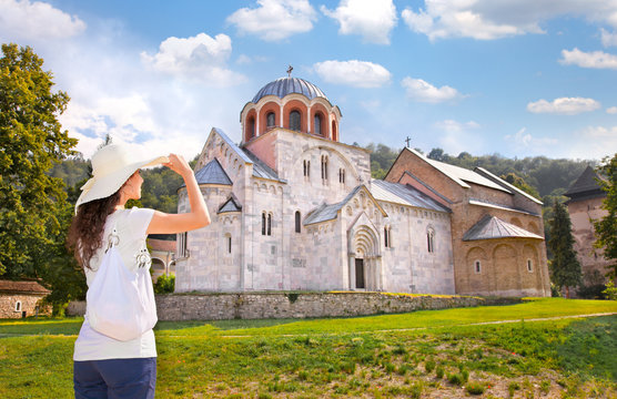 Beautiful young woman in front of Monastery Studenica, Serbia.