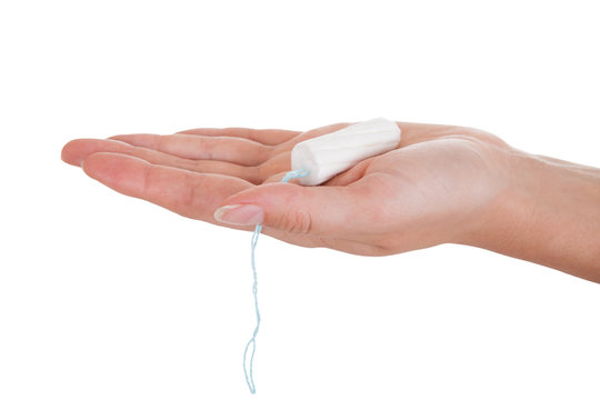 Close up of hand holding tampon