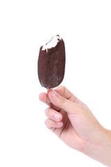 Hand holds bitten chocolate vanilla ice cream.