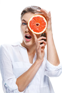 Young beautiful woman with the slice of grapefruit