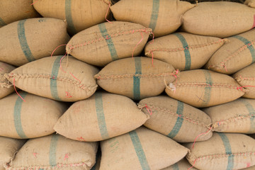 Old hemp sacks containing rice placed profoundly stacked