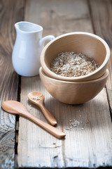 Wooden bowls and a small jug on the wooden background