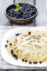 Pancakes and blueberries on wooden table