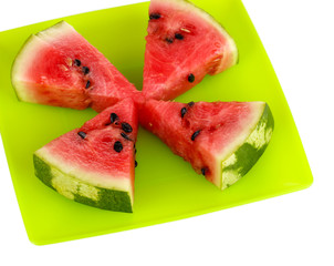 Sweet watermelon slices on green plate isolated on white