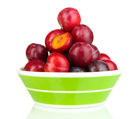 Ripe plums in bowl isolated on white