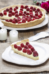 Piece of raspberry tart and big raspberry pie in the background.