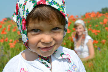 Portrait of the little girl in a colorful kerchief against red p