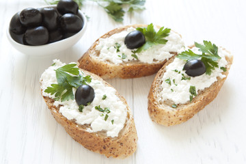 Crostini with cottage cheese, parsley and olive