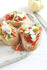 Crostini with red and green pepper and cheese shavings