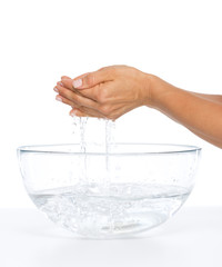 Closeup on young woman washing hands in glass bowl with water