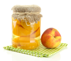 Jar of canned peaches and fresh peaches, isolated on white