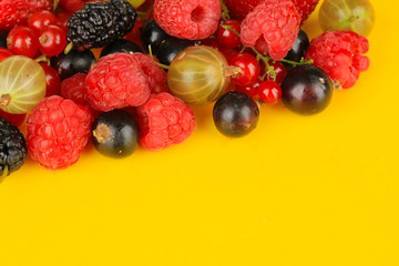 Ripe berries on yellow background