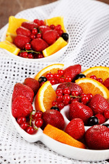 Useful fruit salad in plates on wooden table close-up