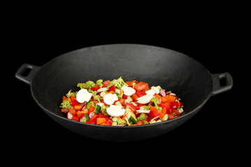 Vegetable ragout in wok, isolated on black