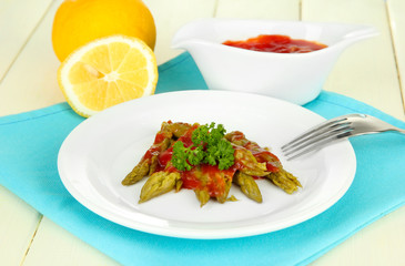Asparagus on plate, on wooden background