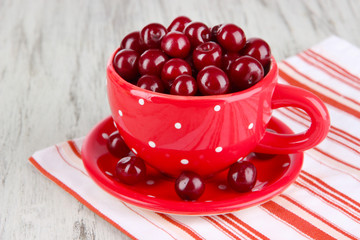 Sweet cherry in cup on table close-up