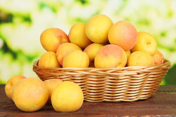 Fresh natural apricot in wicker basket on wooden table