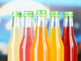 Bottles with tasty drinks on bright background