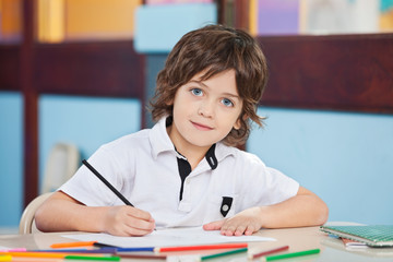 Boy With Sketch Pen And Paper At Desk