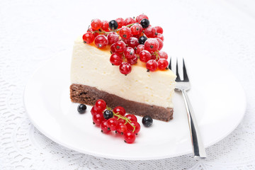 piece of cheesecake, decorated with red and black currants
