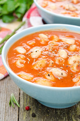 tomato soup with pasta, white beans and rosemary, close-up