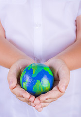 Child holding plasticine globe in hands