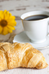 Croissant and cup of coffee in the morning closeup