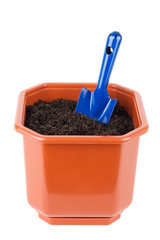 Flower pot with soil and shovel isolated on white