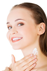 Beautiful woman with healthy skin applying cosmetic cream