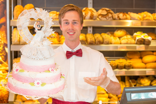 Baker with wedding cake in confectionery